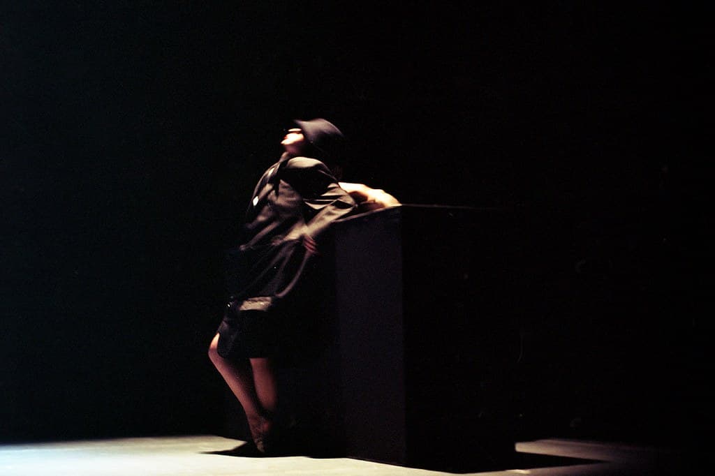 A solo contemporary dancer on a darkened stage