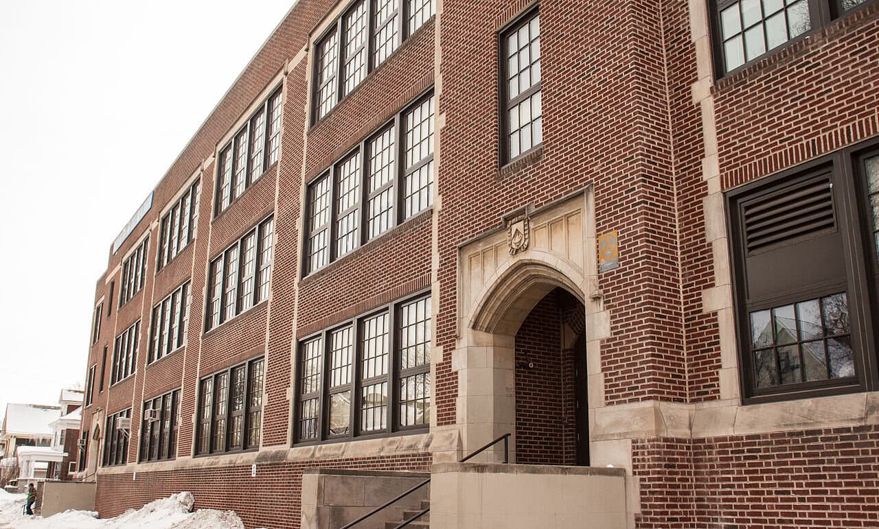 The brick facade and arched entrance of the Minneapolis school building at 1200 West 26th Street that is now Ella Baker Global Studies and Humanities.