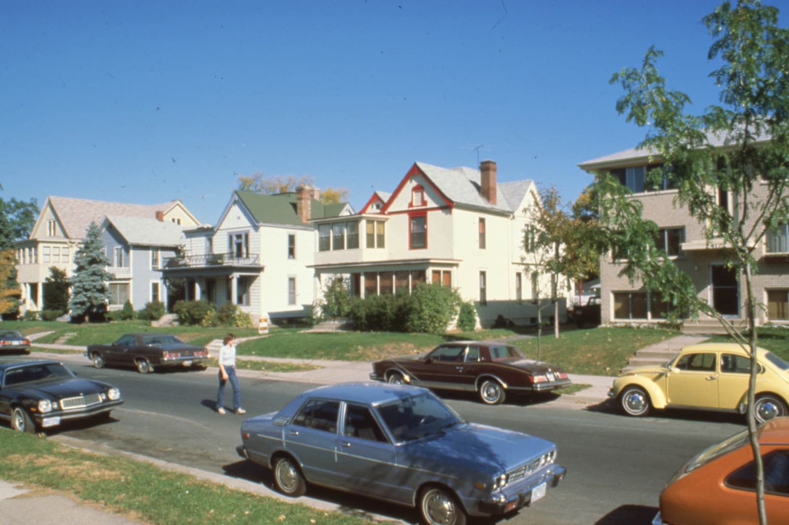 A residential street in Minneapolis with houses and parked cars